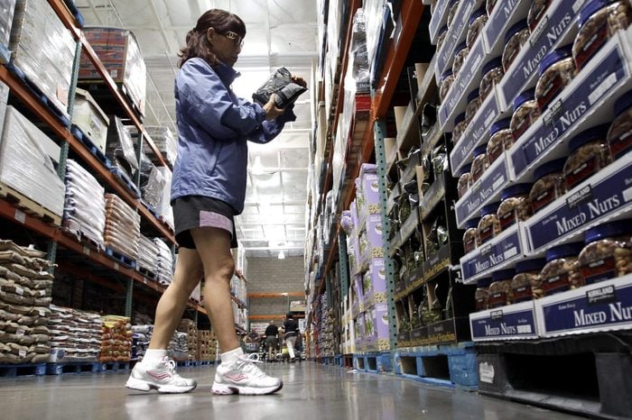 This photo, shows a shopper reading a product label at Costco Wholesale in Mountain View, Calif. Wholesale businesses boosted their stockpiles for a 19th consecutive month in July, but their sales were flat. Faltering demand could force businesses to cut back on orders when the economy is at risk of another recession