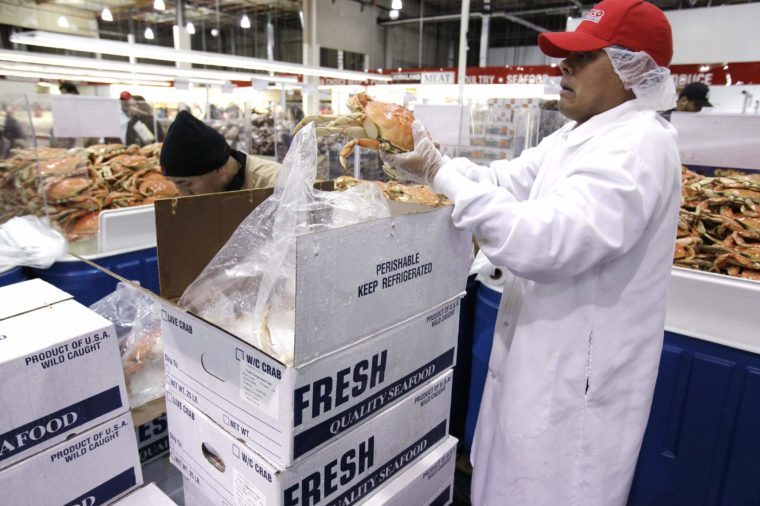 A Costco worker displays cooked Dungeness crab for sale at Costco Wholesale in Mountain View, Calif. . The Dungeness crab season opened this week