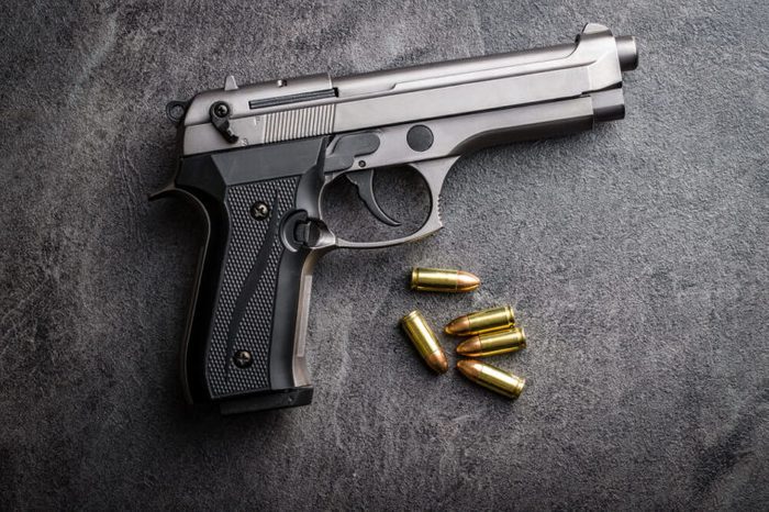 9mm pistol bullets and handgun on black table.