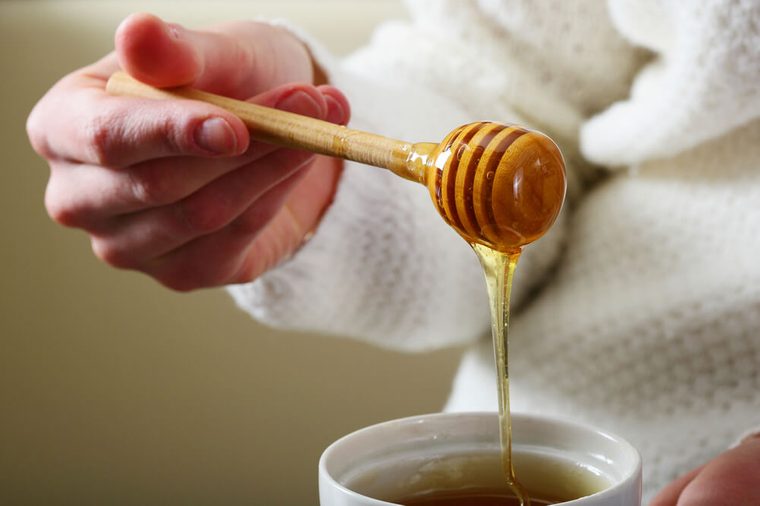 Spoon for honey with female hands