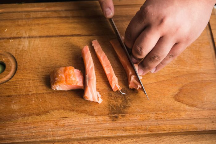 Sushi chef cutting fish