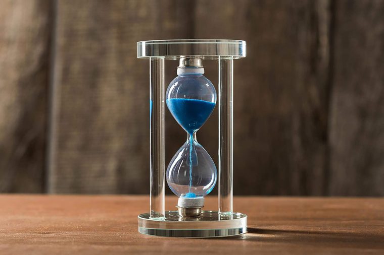 Time is passing. Blue hourglass close up