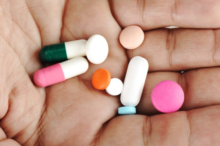 Hand with colorful pills, closeup photo