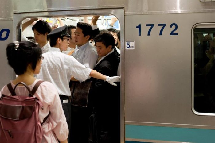 Crowds of commuters on subway tube trains in Tokyo