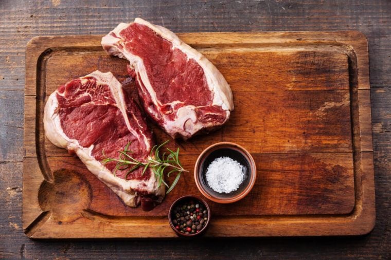 Raw fresh meat Ribeye Steak and seasoning on dark background