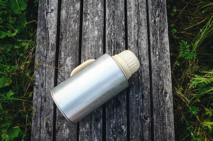 Large old thermos on the background of wooden boards