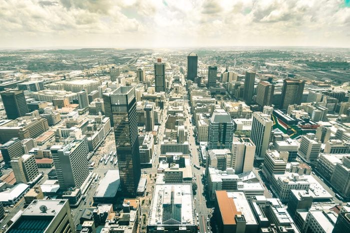 Skyline aerial view of skyscrapers in business district of Johannesburg - Architecture concept with modern buildings of skyline in South Africa biggest city with southafrican flag painted on walls