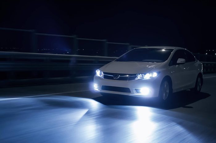 Saratov, Russia - October 23, 2012: White car Honda Civic with xenon headlights fast drive on road at night