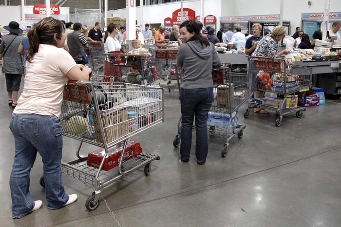 Shoppers wait at the check-out line at Costco Wholesale in Mountain View, Calif. Costco Wholesale Corp.'s fiscal fourth-quarter net income climbed 11 percent as the wholesale club operator made more money on membership fees and saw its sales rise