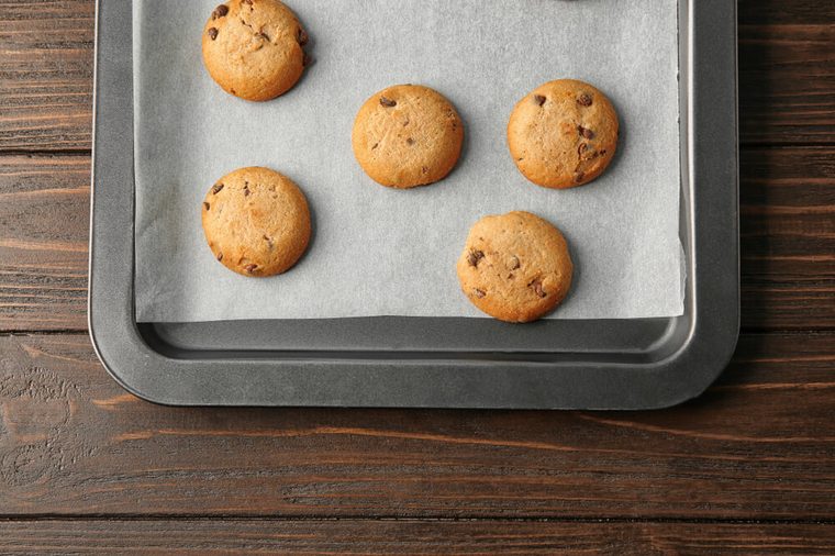 Delicious oatmeal cookies with chocolate chips on baking sheet