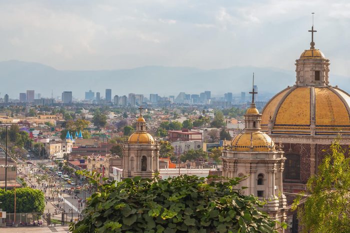 Old Basilica of Guadalupe with Mexico City skyline behind it