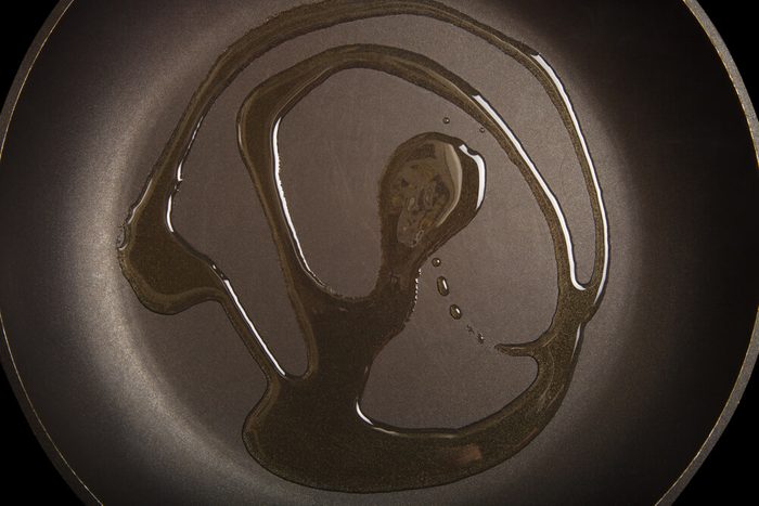 Olive oil on black frying pan. Toned.