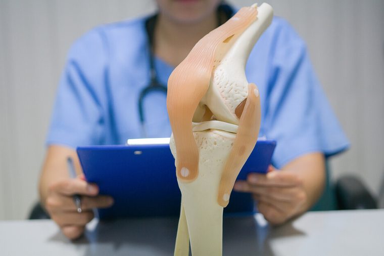 An orthopedic surgeon reads a patient's knee replacement report for analysis and guidelines for postoperative treatment and allows the patient to live a normal life. medical and orthopedic concept.