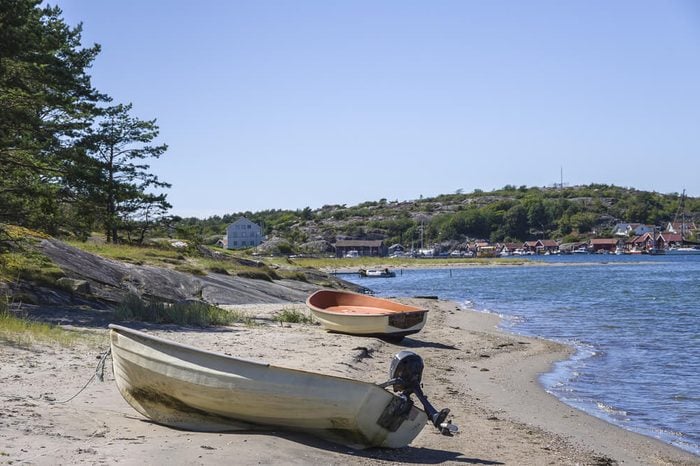 Boats on the shore of South Koster island and view of Nordkoster on North Koster island, Bohuslan County, Sweden.