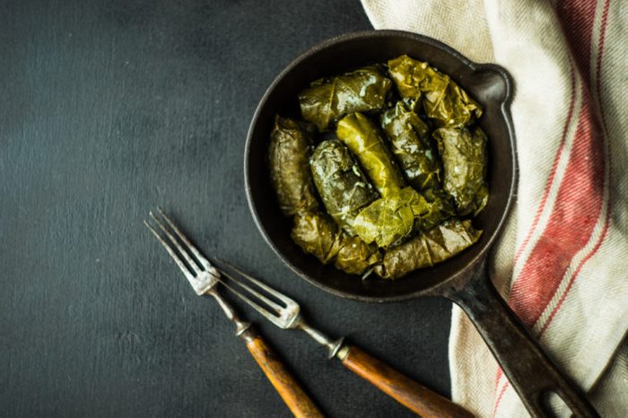 Traditional georgian dolma in grape leaves on rustic wooden table with copyspace
