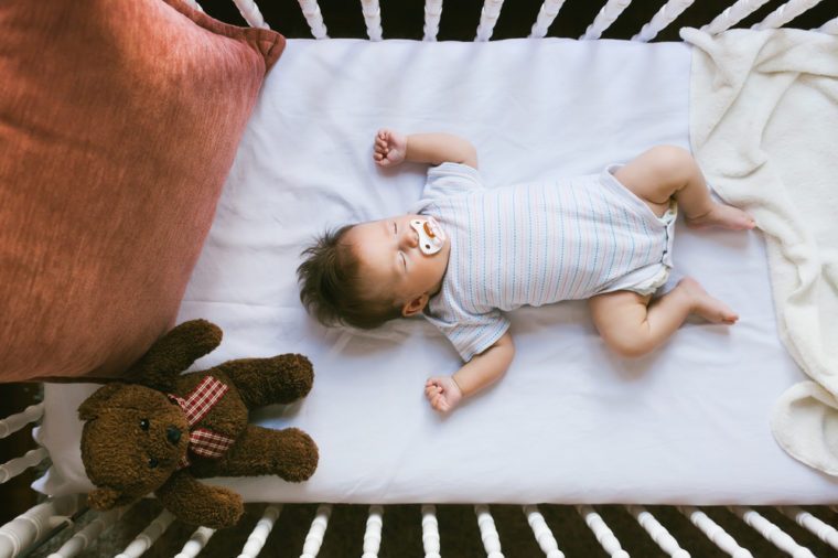 Adorable newborn lies in the crib