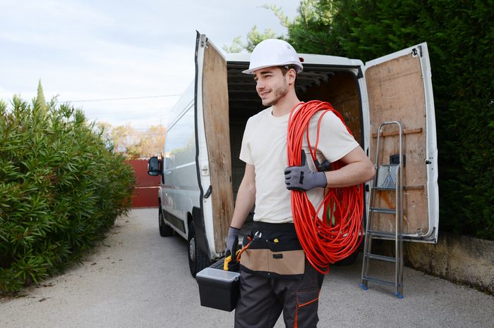 handsome young construction worker with his commercial van on background