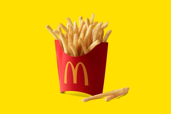 mcdonalds french fries in carton on yellow background