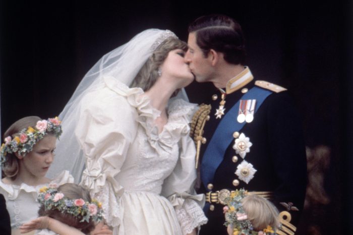 On the balcony of Buckingham Palace Prince Charles and Princess Diana kiss on their wedding day