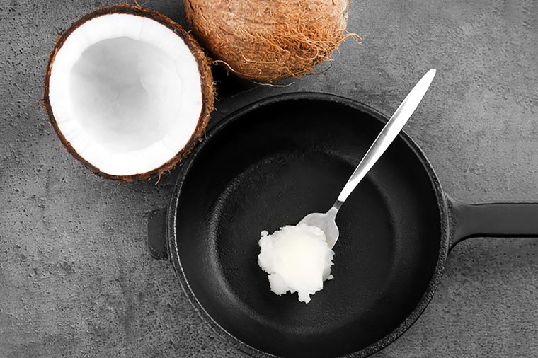 Spoon with coconut oil on frying pan