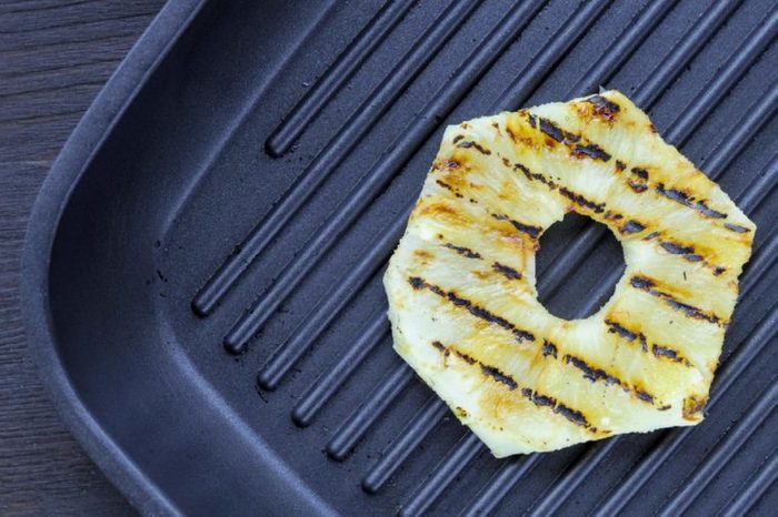 Fried pineapple on the grill. Cooking fish burger.