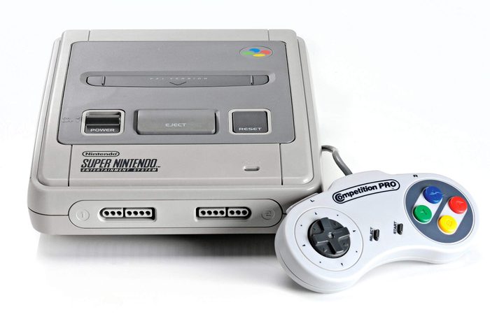 A Super Nintendo Entertainment System Video Game Console And Competition Pro Controller Photographed On A White Background