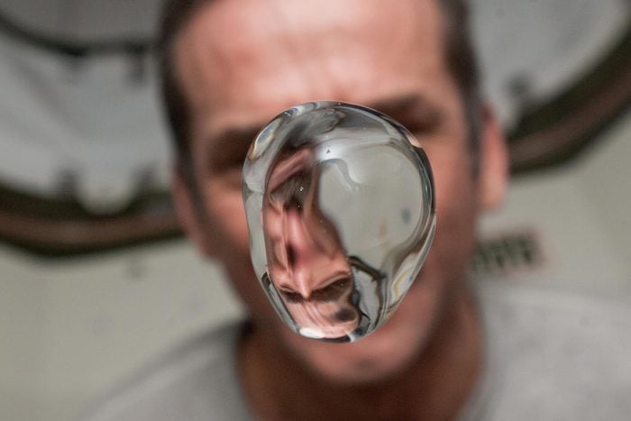 View of Canadian Space Agency (CSA) Chris Hadfield,Expedition 34 Flight Engineer (FE),watching a water bubble float freely,showing his image refracted,in the Node 1. Photo was taken during Expedition 34.
