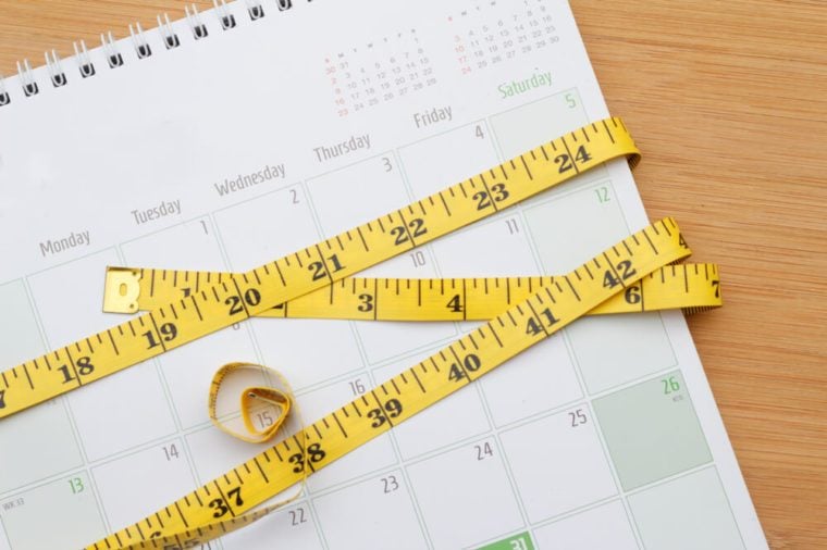 Measurement tape is twisted around the calendar. Weight management concept.