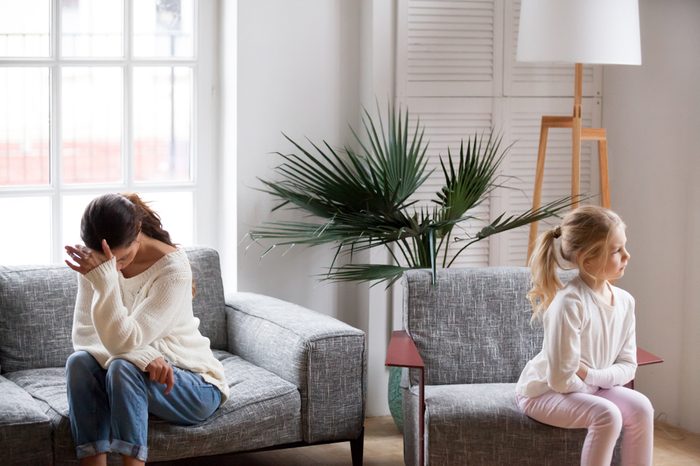 Sad tired mother and sulky angry offended child girl not talking after conflict in living room, stubborn kid daughter pouting ignoring depressed mother upset by argument, family conflict concept