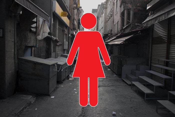 dirty, empty alleyway with woman symbol overlay