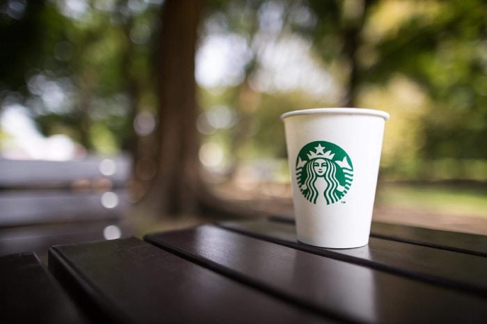 Bangkok ,Thailand - OCTOBER 11, 2016 : A cup of Starbucks hot beverage coffee on the table in the park. Starbucks is the world's largest coffeehouse company