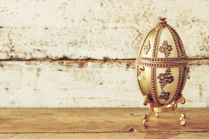 image of gold faberge egg on wooden table. vintage filtered 
