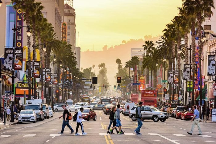 LOS ANGELES, CALIFORNIA - MARCH 1, 2016: Traffic and pedestrians on Hollywood Boulevard at dusk. The theater district is famous tourist attraction.