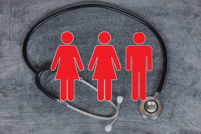 stethoscope on concrete background with woman and man figures overlay