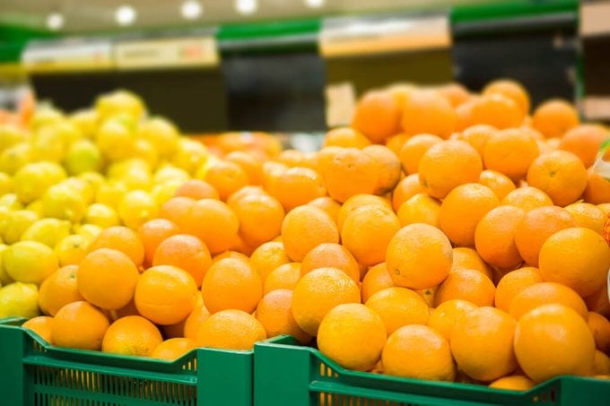 Bunch of oranges and lemons on boxes in supermarket