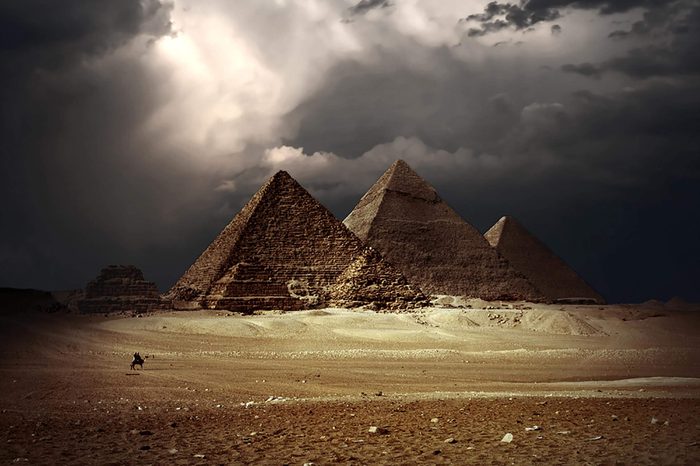Great pyramids in Giza valley with dark clouds on the background