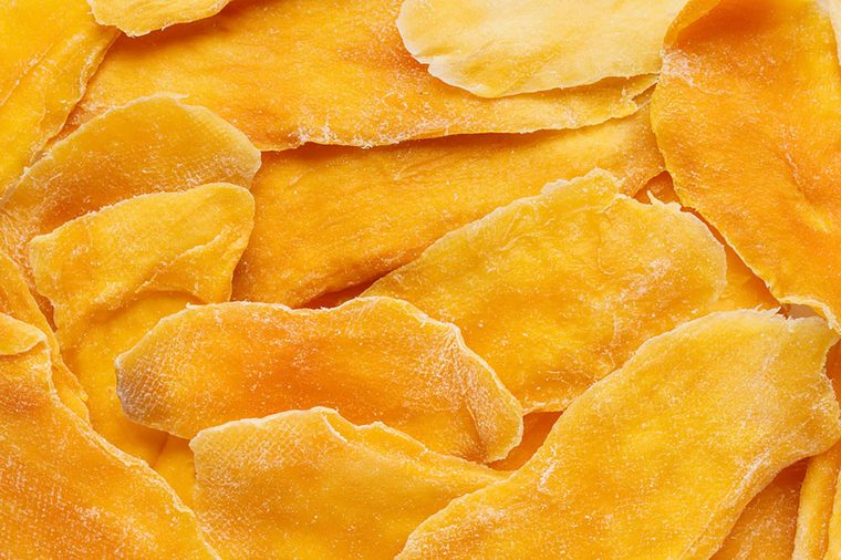 Dehydrated mango as a background. Dried fruits. Natural healthy candy. Top view.