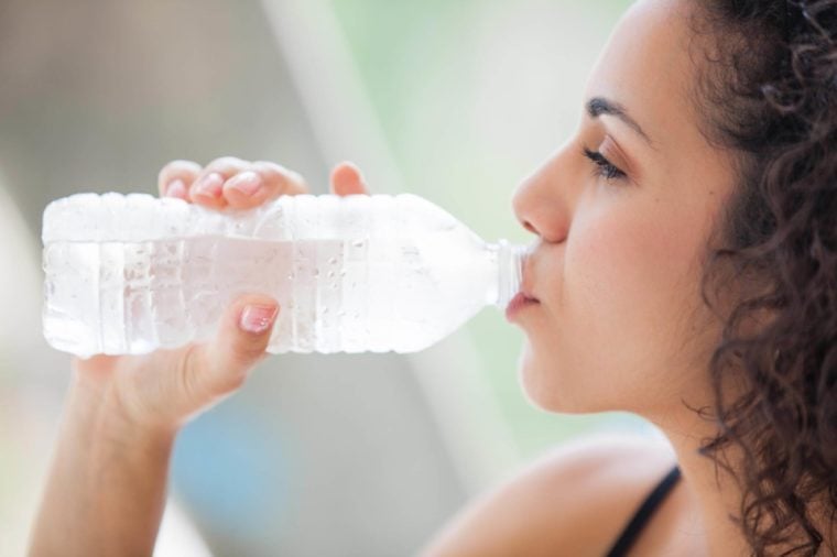 Healthy food, Pretty young woman drinking a bottle of ice cold water