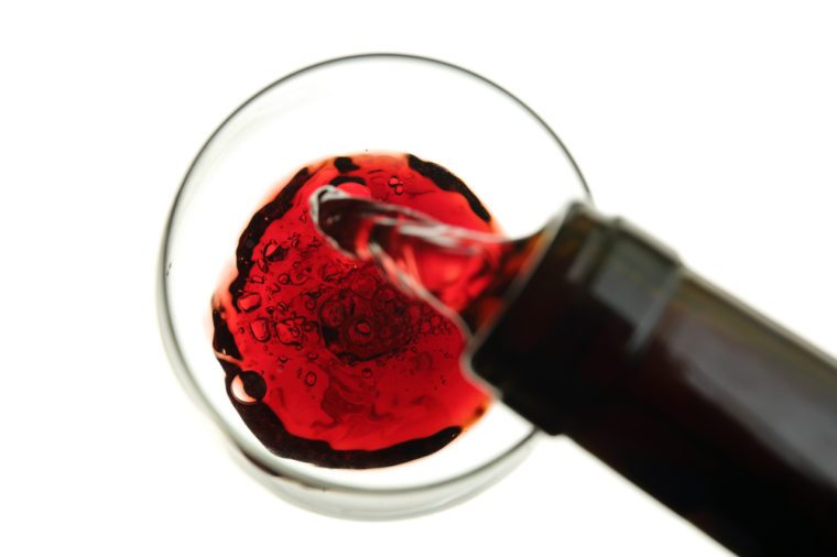 red wine being poured into a glass isolated on white-blurry movement
