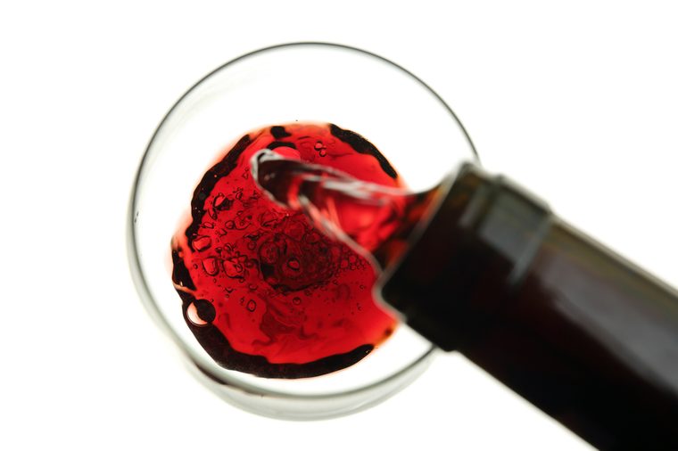 red wine being poured into a glass isolated on white-blurry movement