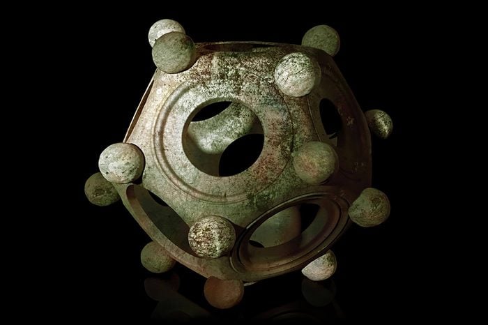 Ancient bronze Roman dodecahedron on a black background