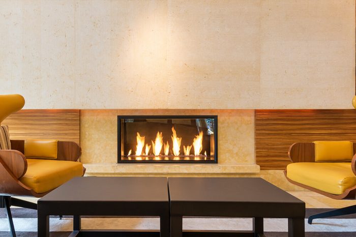 Modern fireplace sitting area with two leather chairs. Interior design.