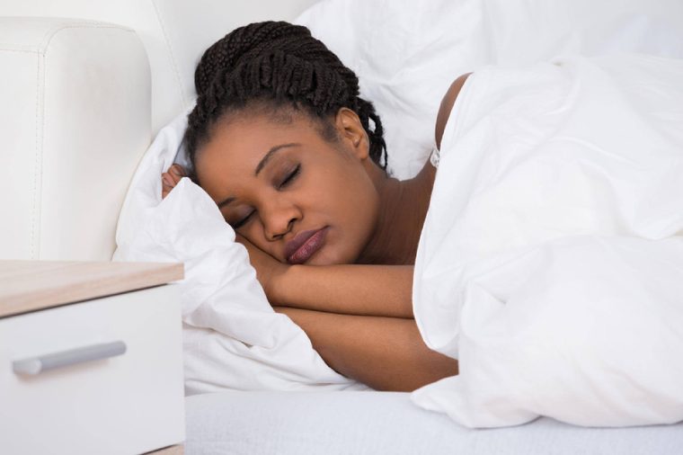 Portrait Of A Young African Woman Sleeping On Bed