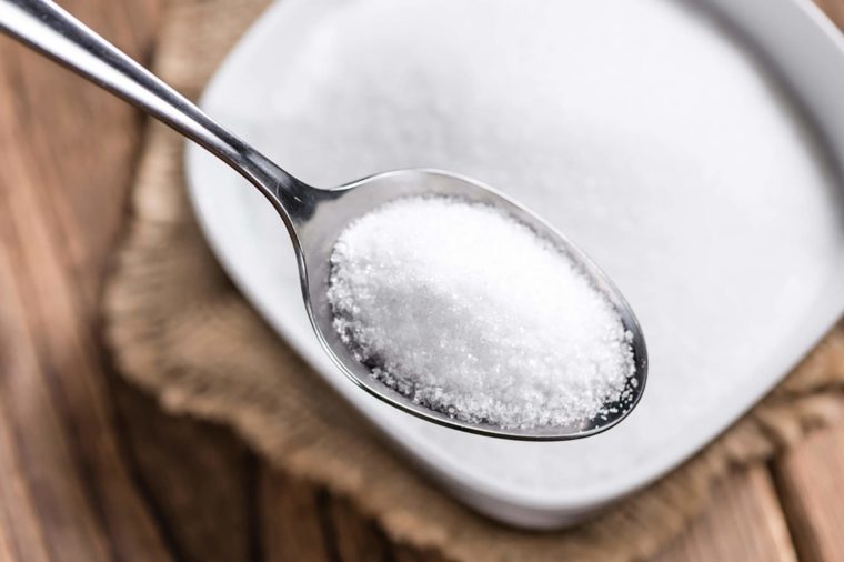 Portion of White Sugar (detailed close-up shot; selective focus) on wooden background