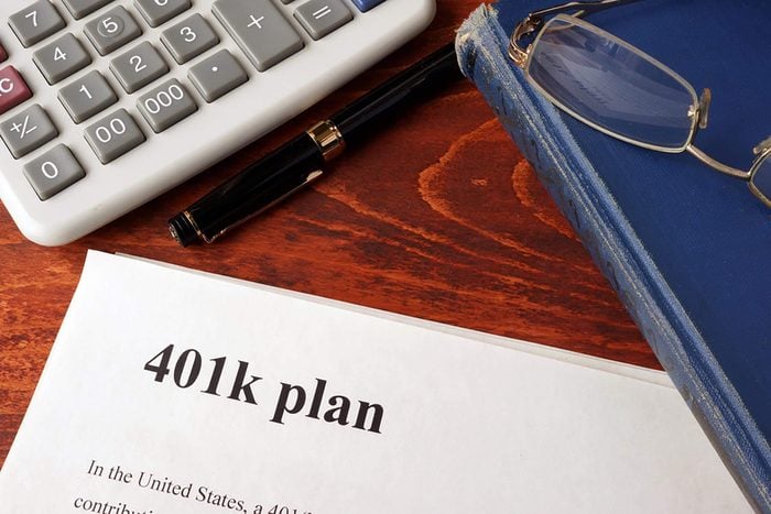 Papers with 401k plan and book on a table.