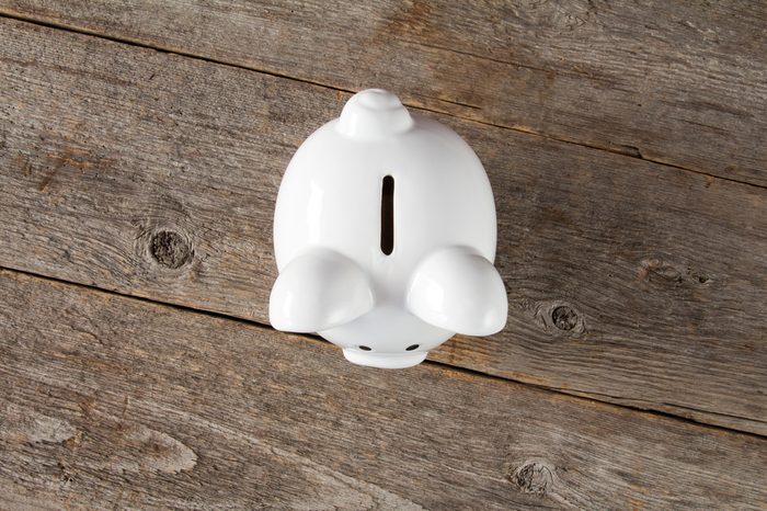 White piggy-bank on the old wooden background. Top view.