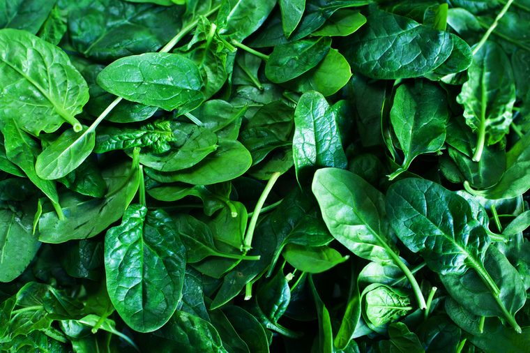 Fresh green baby spinach leaves background close up