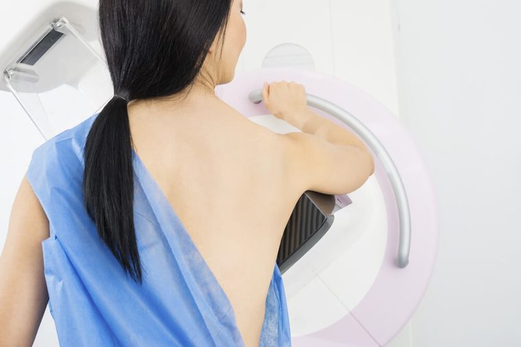 Woman Standing In Front Of Mammography Machine