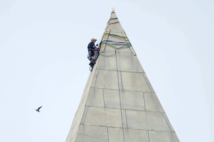 attaches ropes to the top of the Washington Monument