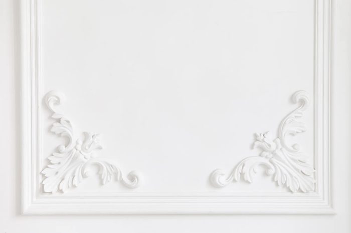 The white wall is decorated with exquisite elements of plaster moldings